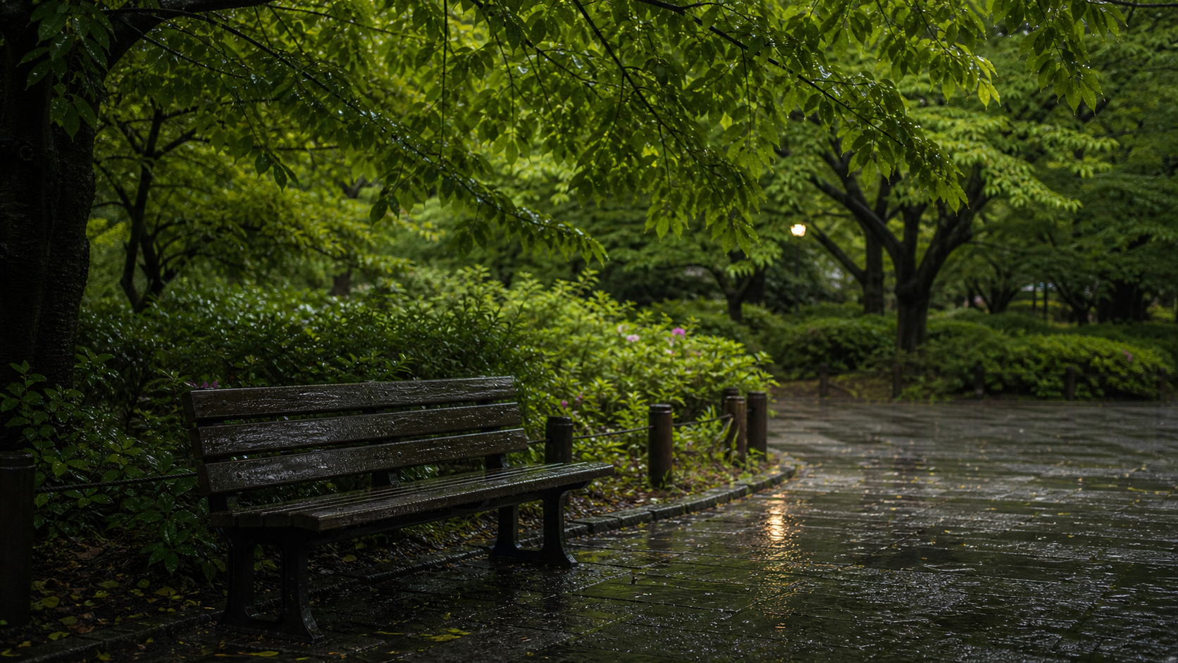 架空の都市公園。小雨のあとの木陰と濡れたベンチに、若葉の光がやわらかく残っている。